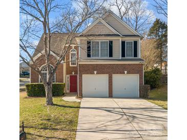 Charming two-story home with a red door, a two-car garage and a well-manicured front lawn at 3203 Arklow Rd, Charlotte, NC 28269