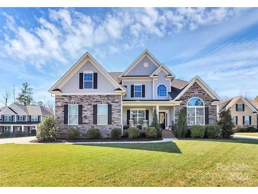 Charming two-story home showcasing a stone and siding exterior, complemented by a lush, green lawn at 5019 Mill Creek Rd, Clover, SC 29710