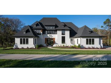 Stunning two-story home showcasing black frame windows, white painted brick, and a manicured lawn at 1004 Maxwell Ct # 1, Marvin, NC 28173