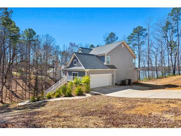 Gray two-story home with an attached two-car garage on a large lot with lake access at 13701 Petworth Ct, Charlotte, NC 28278