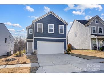 Charming two-story home showcasing a well-manicured lawn and a driveway leading to a two-car garage at 5010 Arbordale Way # 5, Mount Holly, NC 28120