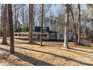 Charming home featuring an expansive front porch and gazebo, set amid a wooded landscape at 107 Rutledge Rd, Mount Holly, NC 28120