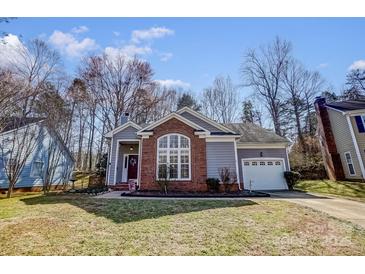 Charming home with large front window, brick accent, attached garage, and well maintained lawn at 11010 Pale Hickory Ln, Charlotte, NC 28215