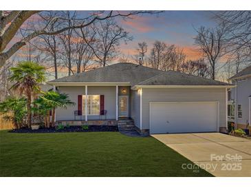 Charming single-story home with a well-manicured lawn, complemented by a two-car garage and inviting front porch at 125 Rocky Trail Ct, Fort Mill, SC 29715