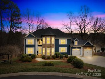 Charming two-story home with stone accents, three-car garage, and beautifully landscaped yard at 228 Wildwood Cove Dr, Mooresville, NC 28117