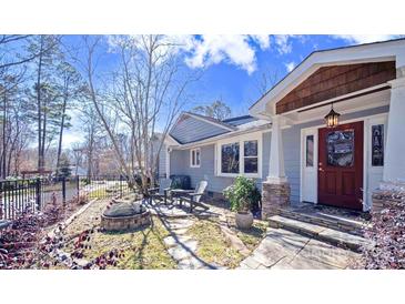 Charming front entrance featuring a cozy stone patio, red door, and serene outdoor seating area at 549 Briarwood Ln, Lancaster, SC 29720