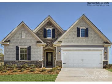 Charming home featuring a stone-accented facade, two-car garage, and well-manicured lawn at 8422 Norman Forest Rd, Lancaster, SC 29720