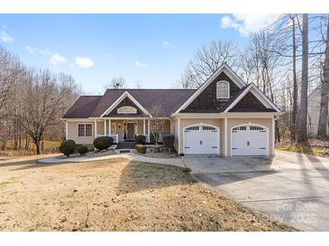 Charming ranch-style home featuring a two-car garage, covered porch, and well-manicured landscaping at 153 Byers Rd, Troutman, NC 28166