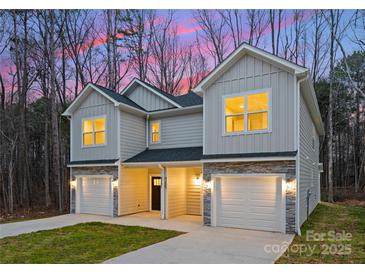 Charming townhome exterior featuring stone accents, single car garages and a well-manicured lawn at 2117 Gemway Dr, Charlotte, NC 28216