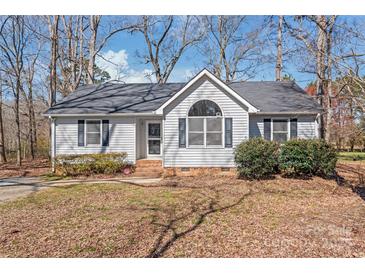 Charming single-story home featuring a well-manicured lawn, gray siding, and a classic roofline at 2913 Ashley Woods Ct, Monroe, NC 28112