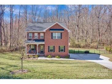 Charming two-story red brick home with a welcoming front porch and manicured lawn at 320 Heritage Pl, Mooresville, NC 28115