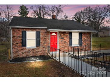 Charming brick home featuring a bright red front door, black shutters and landscaped front at 621 E Sharpe St, Statesville, NC 28677