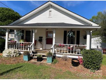 Charming home with a cozy front porch and beautifully landscaped front yard filled with potted plants and flowers at 1001 N Cannon Blvd, Kannapolis, NC 28083