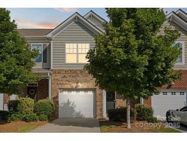 Charming townhome with a brick and siding facade, one-car garage and mature trees at 3306 Yarmouth Ln, Gastonia, NC 28056