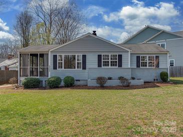 Charming single-story home features a well-manicured lawn, classic shutters, and a screened in porch at 5300 Buckingham Dr, Charlotte, NC 28209