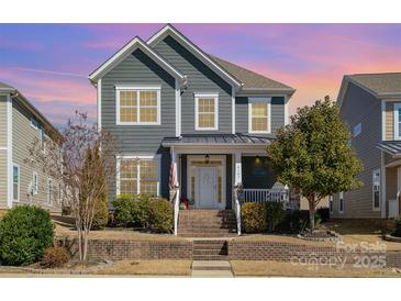 Charming two-story home featuring a welcoming front porch, well-maintained landscaping, and a beautiful gray facade at 6187 Cloverdale Dr, Tega Cay, SC 29708