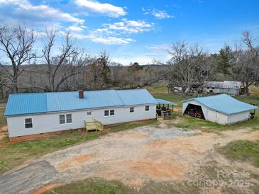 Charming home with a blue roof and a detached garage, set on a spacious lot with mature trees at 836 Love Rd, Blackstock, SC 29014