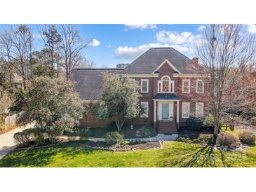 Charming two-story brick home with well-manicured landscaping and a welcoming light-blue front door at 10207 Rattersly Ct, Charlotte, NC 28277
