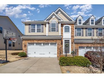 Charming townhome with stone accents, a two-car garage, and a well-maintained lawn in a desirable neighborhood at 121 Inlet Point Dr, Tega Cay, SC 29708