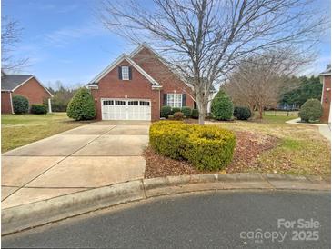Charming brick home with a two-car garage and well-manicured landscaping at 2702 Occaneechi Ct, Waxhaw, NC 28173