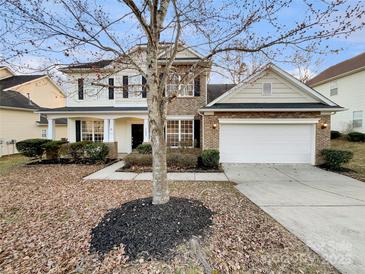 Charming two-story home with brick and siding exterior, two car garage, and well-manicured lawn at 5002 Fine Robe Dr, Indian Trail, NC 28079