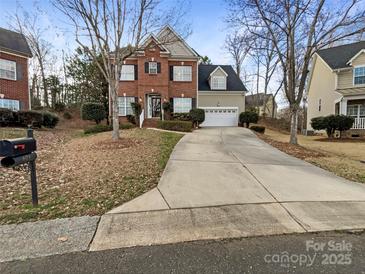 Charming two-story home with a well-maintained lawn and a long driveway leading to an attached garage at 621 Ravenglass Dr, Fort Mill, SC 29715