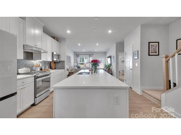 Modern kitchen boasts a large island, stainless steel appliances, and an open layout at 6278 Ashton Park Dr, Denver, NC 28037