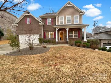 Charming two-story brick home with red shutters and a welcoming front porch at 705 Old Cove Rd, Tega Cay, SC 29708