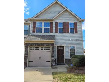 Charming two-story townhome with a single-car garage and classic brown shutters against pale siding at 11142 Jc Murray Nw Dr, Concord, NC 28027