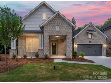 Charming brick home with a well-manicured lawn and inviting covered entryway at 13134 Macon Hall Dr, Mint Hill, NC 28227