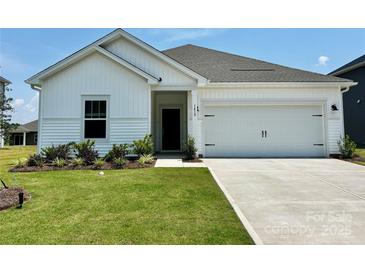 Charming single-story home with a manicured lawn and a two-car garage, providing both curb appeal and practicality at 1418 Windy Park Dr, Stanley, NC 28164
