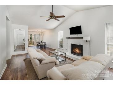 Bright living room boasts a fireplace, ceiling fan, and seamless flow to the dining area, perfect for modern living at 3428 Braewick Pl, Charlotte, NC 28227