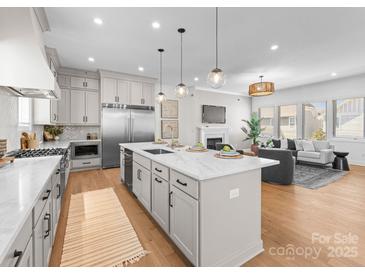 Bright living room with open concept kitchen, fireplace, and hardwood floors at 4207 Walker Rd, Charlotte, NC 28211