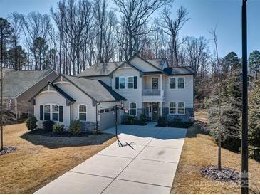 Charming two-story home featuring a spacious driveway, attached garage, and landscaped front yard on a sunny day at 5050 Watersail Way, Lake Wylie, SC 29710