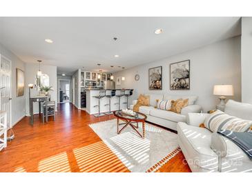 Bright open-concept living room featuring hardwood floors, modern furnishings and access to the kitchen at 509 N Graham St # 2D, Charlotte, NC 28202