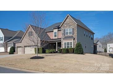 Charming two-story home featuring a stone and brick facade, complemented by a manicured lawn and mature landscaping at 865 Kathy Dianne Dr, Fort Mill, SC 29707