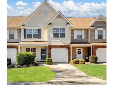 Charming townhome featuring a well-manicured lawn, attached garages, and a welcoming facade at 11420 Glaetzer Ln, Charlotte, NC 28270