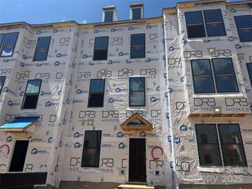 New townhome construction showcasing large windows and modern design elements on a sunny day at 15336 Ballancroft Pkwy # 16, Charlotte, NC 28277