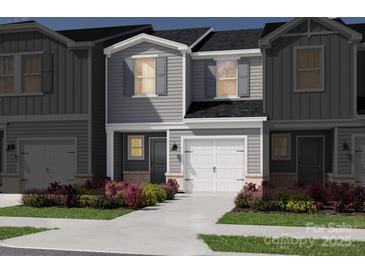 Charming gray two-story townhome featuring a one-car garage and beautifully landscaped front yard at 5013 Kellaher Pl, Charlotte, NC 28216
