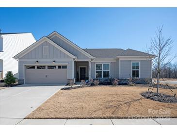 Charming single-story home with a well-manicured lawn and attached two-car garage at 11031 Larkslea Ln, Charlotte, NC 28278