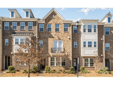 Charming brick townhome featuring a small balcony and well-maintained landscaping at 11537 Red Rust Ln, Charlotte, NC 28277