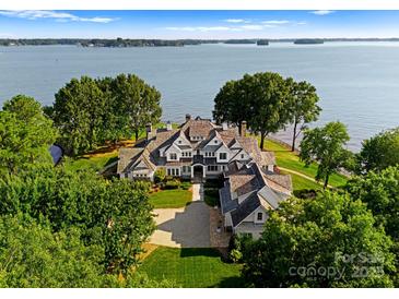 Expansive lakefront estate featuring a large lawn, mature trees and beautiful architectural design at 124 Wellcraft Ct, Mooresville, NC 28117
