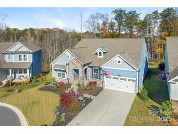 Charming two-story home featuring a stone facade, blue accents, an attached garage and manicured front yard at 2894 Westshore Pl, Denver, NC 28037