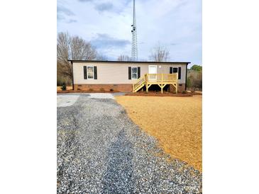 Charming one-story home featuring a spacious gravel driveway and a welcoming wood deck at 2950 Old Cliffside Rd, Shelby, NC 28152