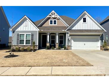 Charming single-Gathering home boasts stone accents, gray siding, and a well-manicured front yard at 3309 Juneberry Pl, Indian Land, SC 29707