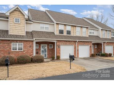 Charming townhome featuring brick facade, attached garage, and landscaped front yard at 349 Valley Brook Se Ln, Concord, NC 28025