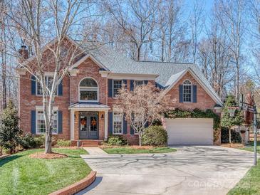 Stately brick home featuring a manicured lawn, driveway, and attached garage at 8111 Sealey Ct, Charlotte, NC 28277