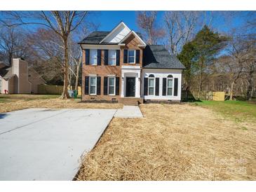 Charming two-story home with brick and vinyl siding, black shutters, and a manicured front yard at 8733 Canter Post Dr, Charlotte, NC 28216