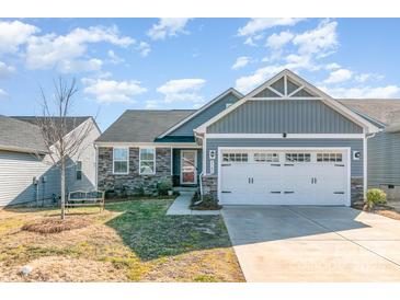 Charming single-Gathering home with stone accents, gray siding and a spacious two-car garage at 9740 Wardley Dr, Charlotte, NC 28215