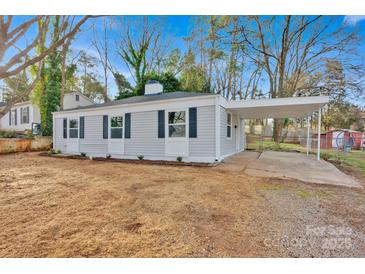 Charming single-story home featuring light gray siding, black shutters and a covered parking area at 1008 Bose Ave, Rock Hill, SC 29732